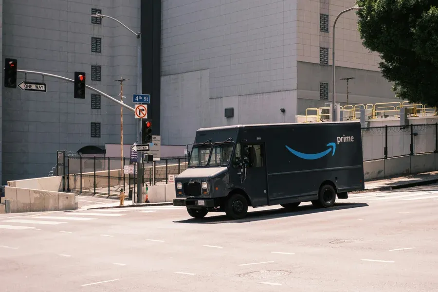 Black Amazon Prime delivery van crossing an intersection in Los Angeles