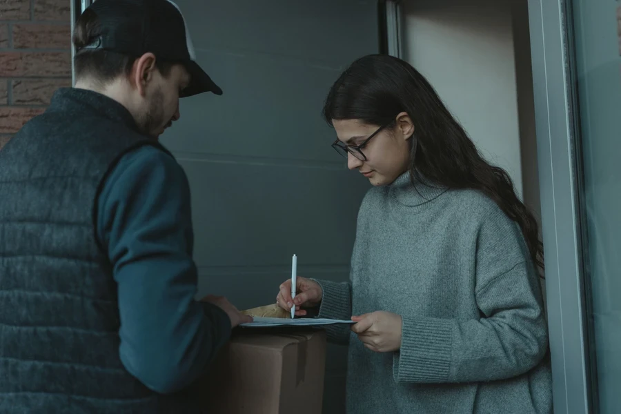 Customer signing for a parcel at her front door