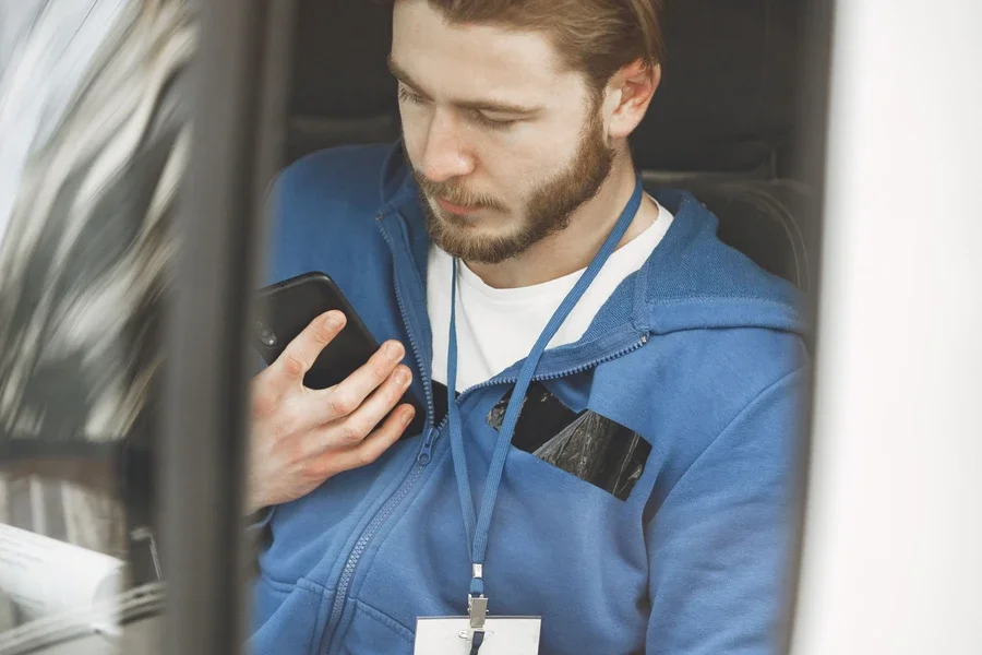 Delivery driver sitting in his van checking the next job on his phone