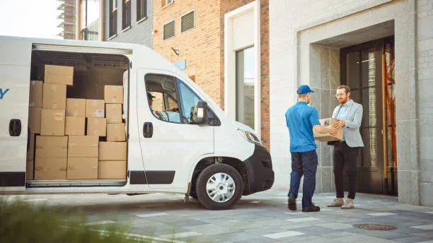 Updating his delivery status Shot of a delivery man reading addresses while sitting in a delivery van delivery driver stock pictures, royalty-free photos & images