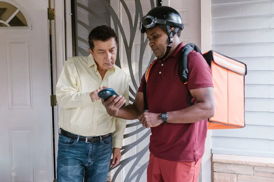 Courier handing an order to a customer at their front door