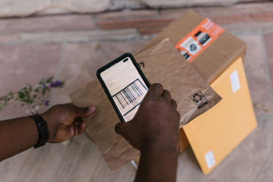 Courier scanning a parcel barcode with a smartphone