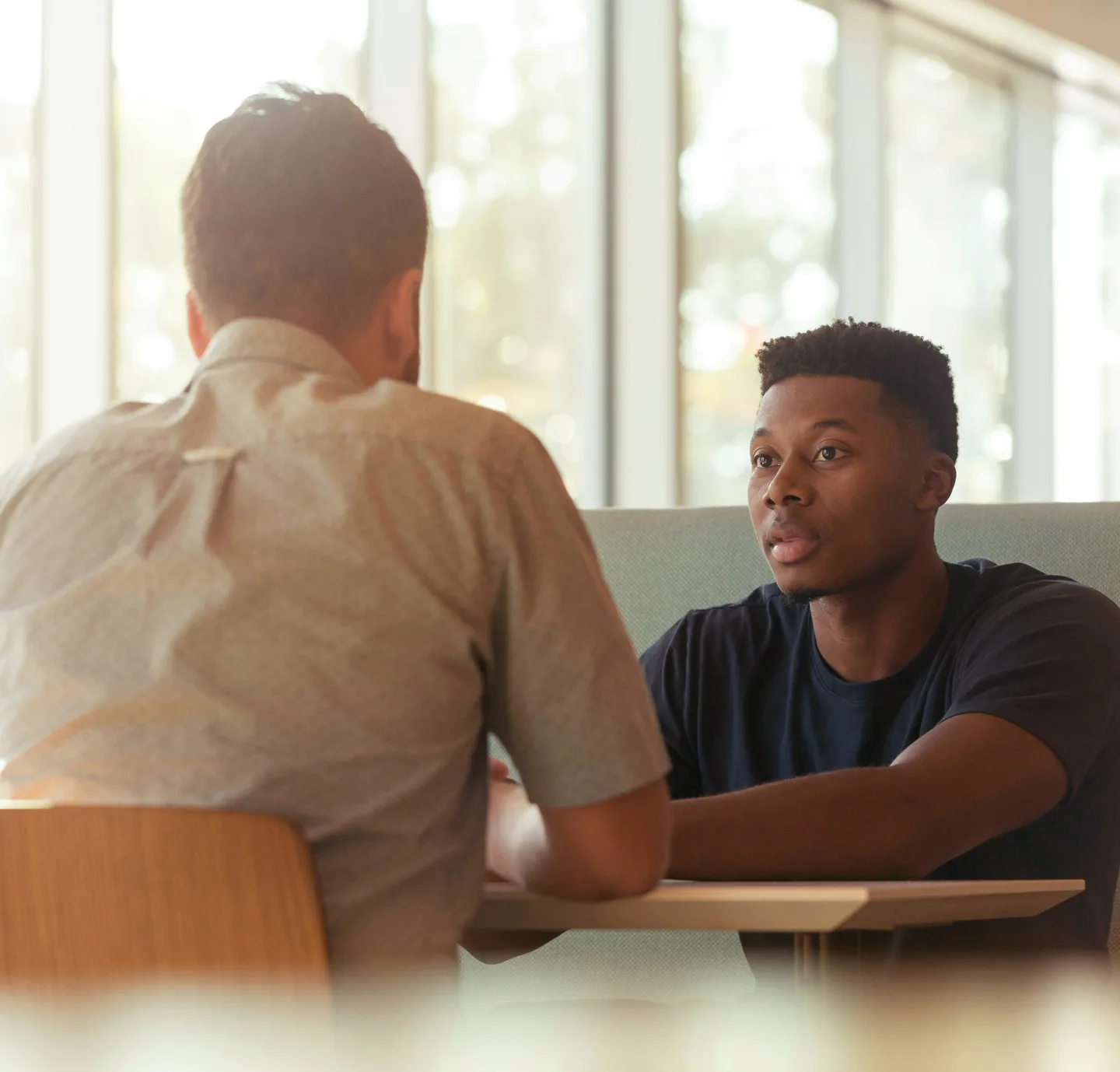 Two people talking across a table in a job interview