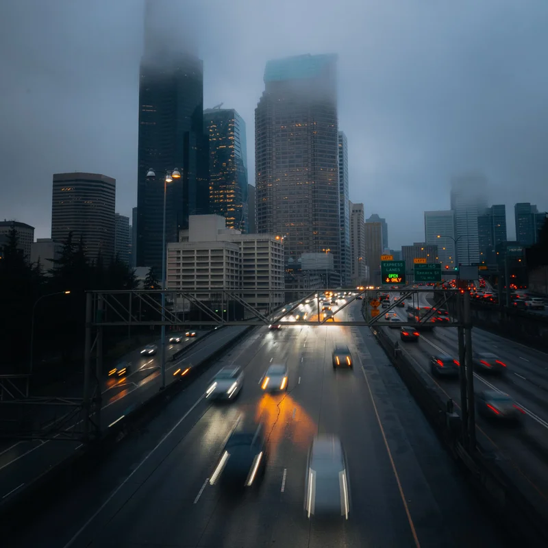 Evening traffic on Interstate 5 heading into downtown Seattle, with the tops of the towers lost in low cloud