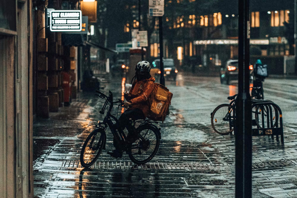 Cycle food courier riding in rain